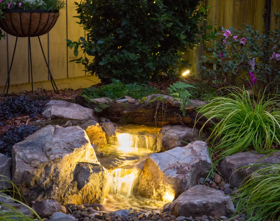 Backyard-waterfall-with-a-lighting-upgrade - Grass Roots Pond And Garden Backyard waterfall with a lighting upgrade