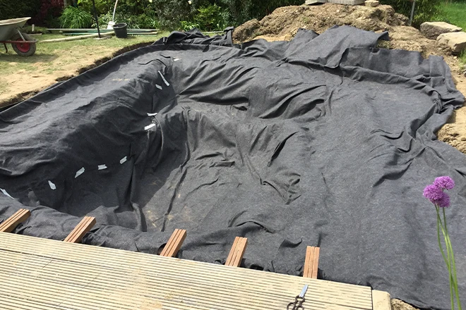 A backyard koi pond being built with the best pond liner
